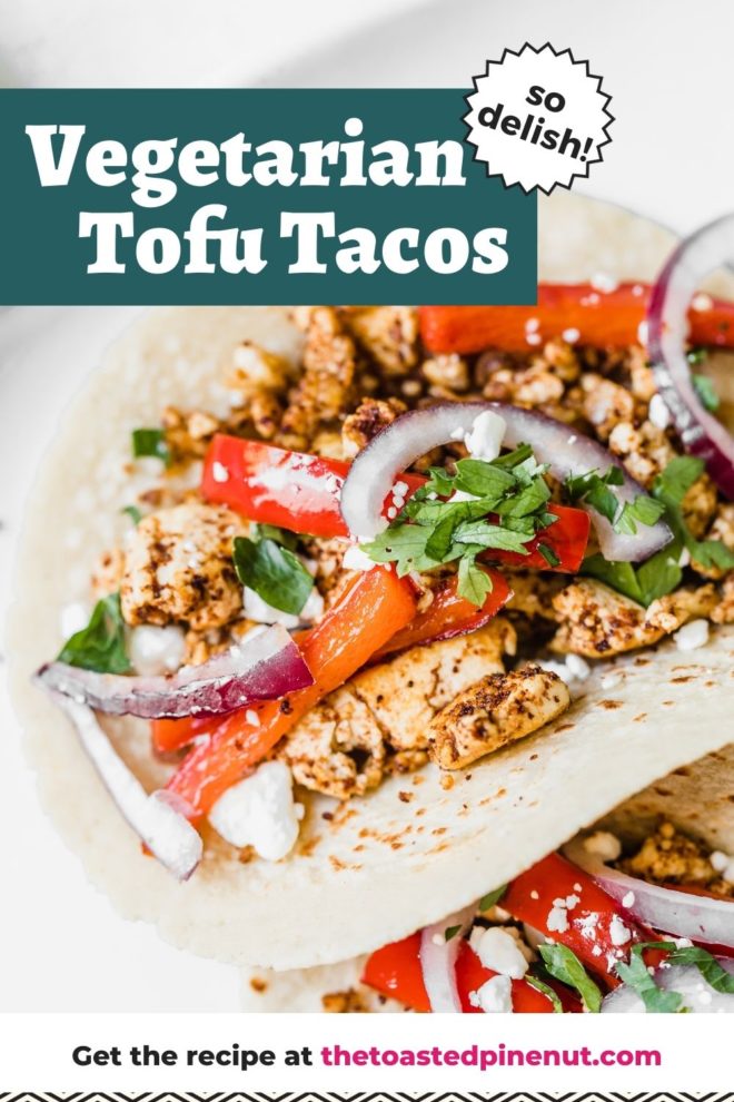 This is a closeup of tacos with crumbled spiced tofu, topped with red bell pepper strips and red onion. The tacos have crumbled cheese with cilantro on top. The taco is nestled next to another taco and on a white plate. Text overlay reads "vegetarian tofu tacos so delish!"