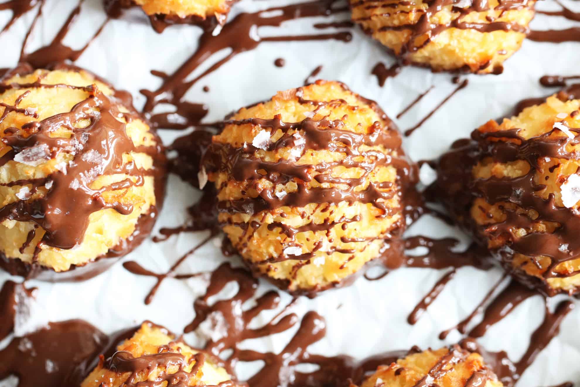 overhead image of coconut macaroons with melted chocolate drizzle on top with a white background 