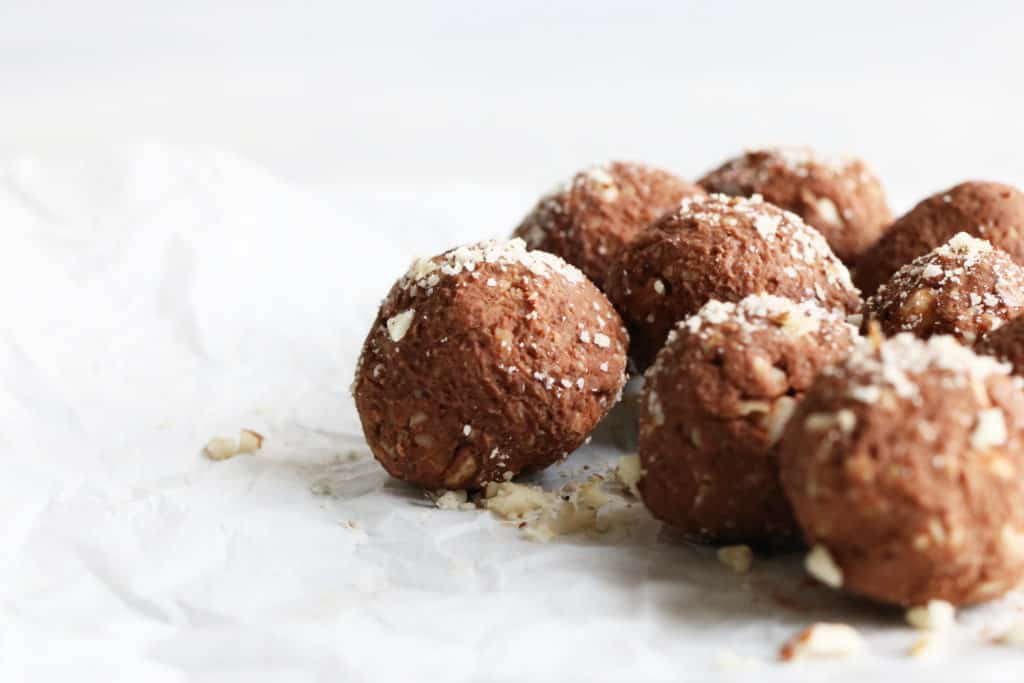 group of chocolate brazil nut energy balls on white parchment paper