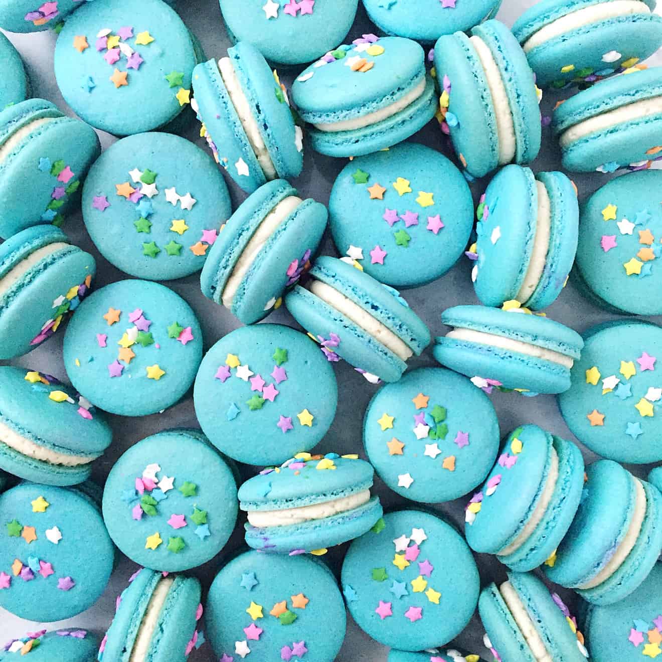 blue french macarons with star sprinkles and vanilla icing filling