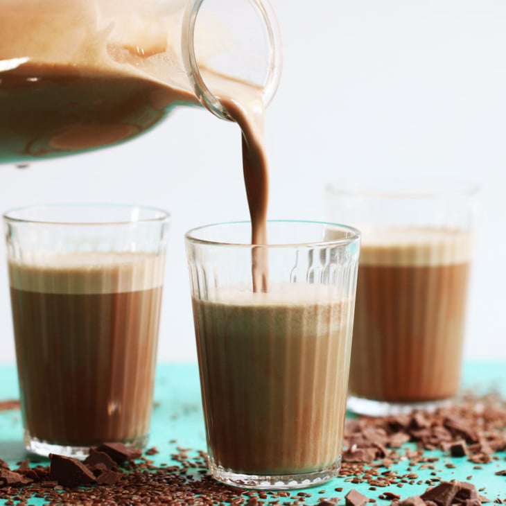 glass pitcher filled with creamy chocolate flax milk poured into small glass cups