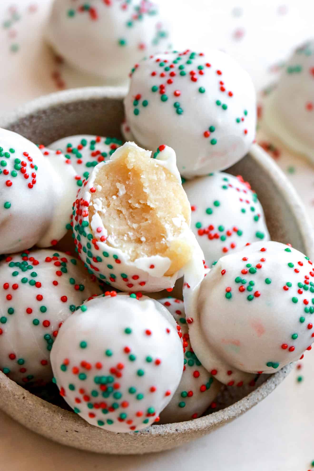 side view of a bowl of no bake sugar cookie truffles with 