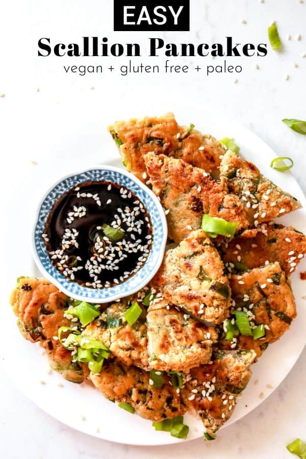 plate of scallion pancakes with small bowl of soy sauce on white background