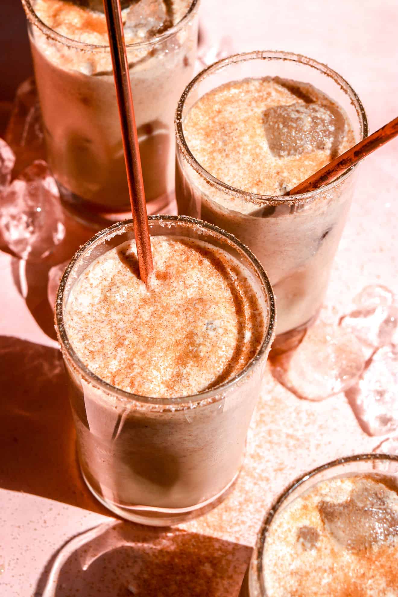 group of ice horchata glasses on pink table