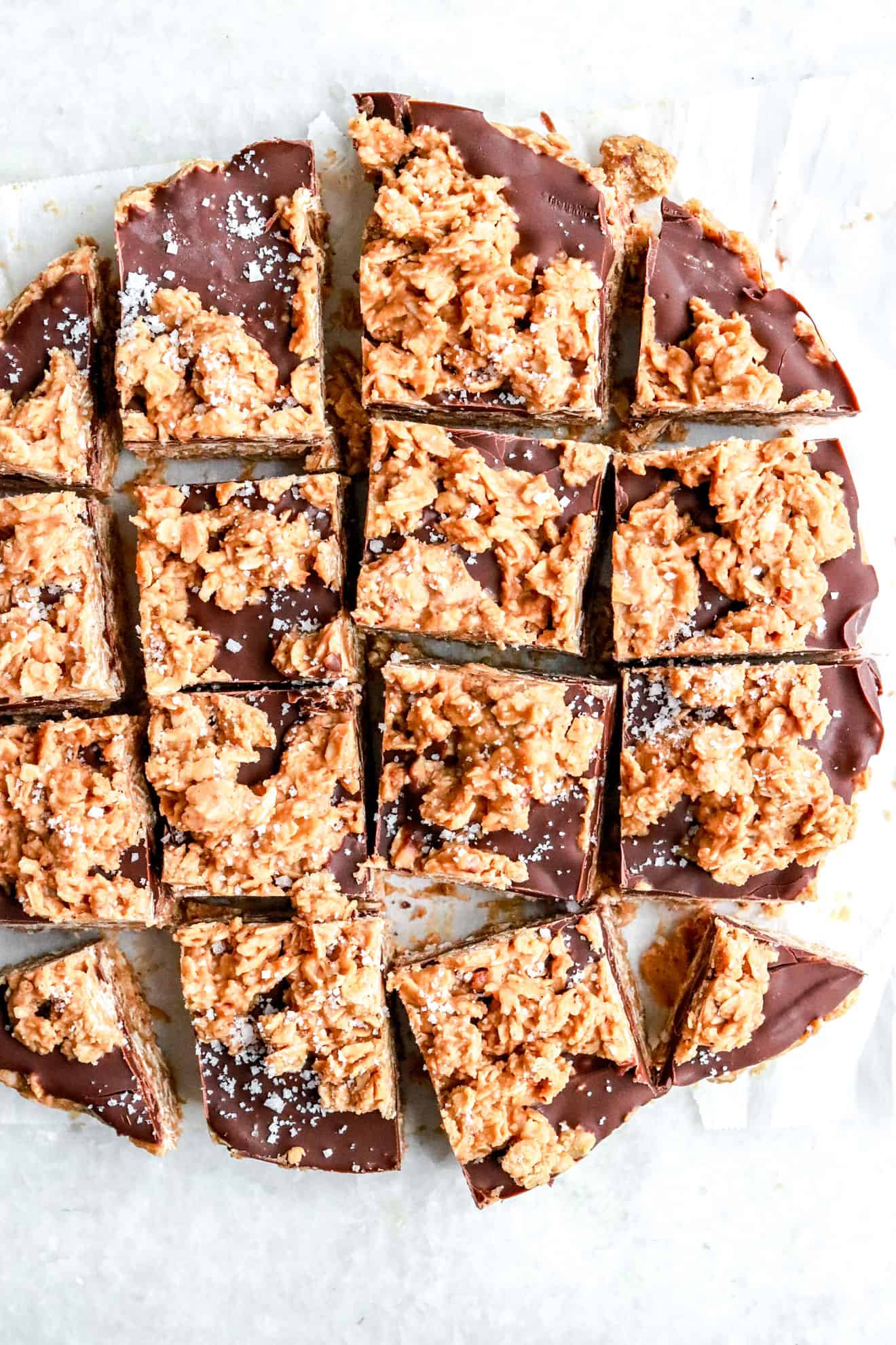 no bake chocolate and peanut butter oatmeal bars cut into squares on white parchment paper background