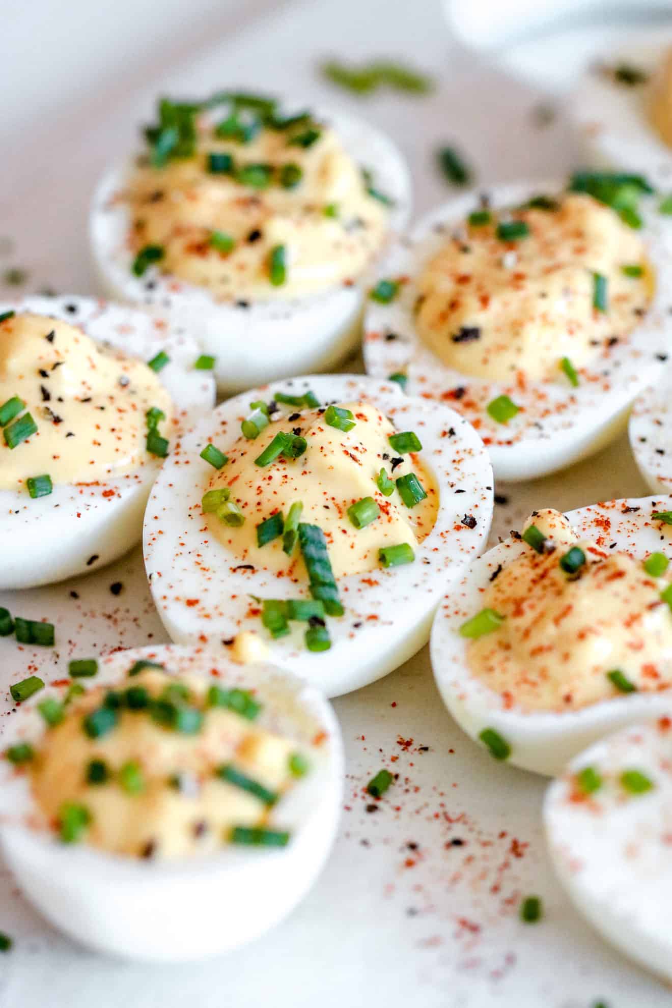 tray of deviled eggs with smoked paprika and chopped chives on top