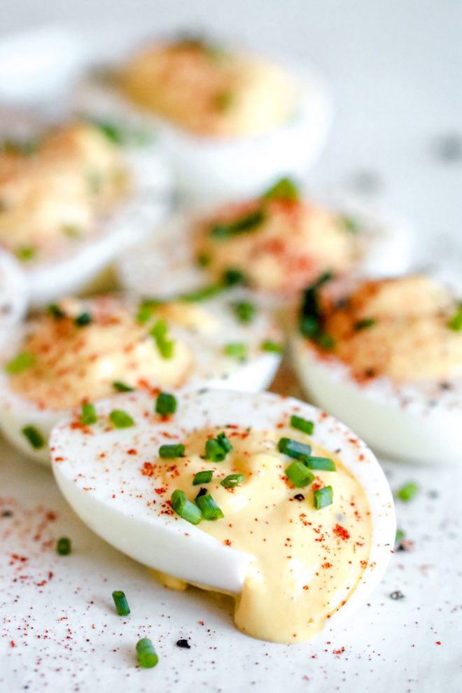 side image of deviled eggs with smoked paprika sprinkled on top and chopped chives