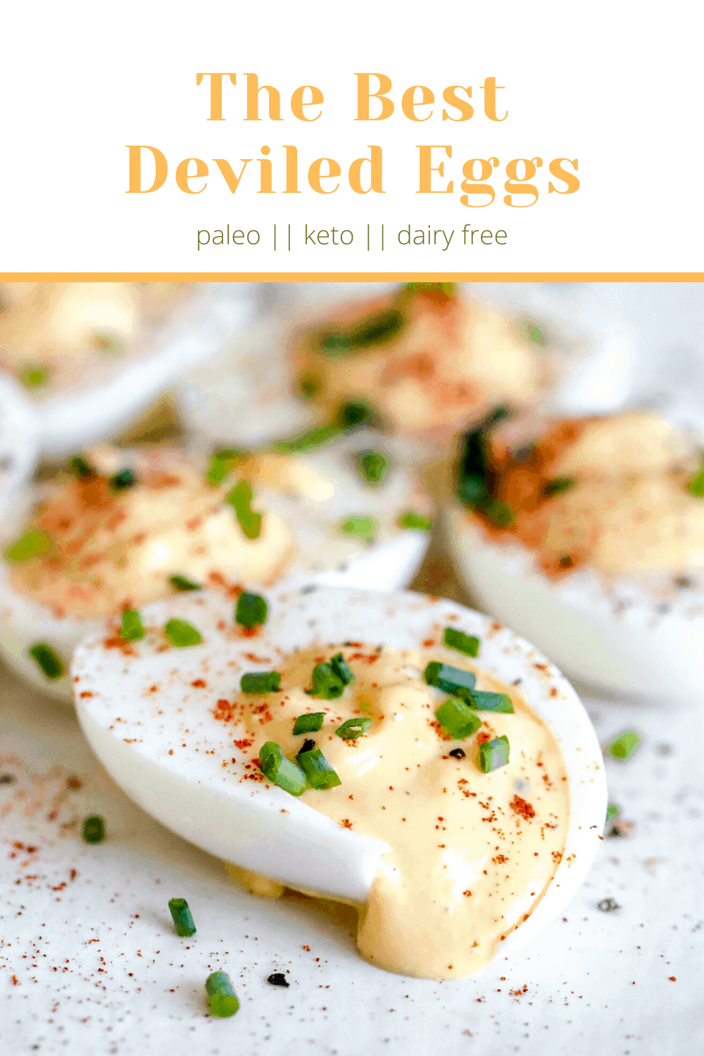 pinterest image of a side view of deviled eggs with filling oozing out and garnished with paprika and chopped chives.
