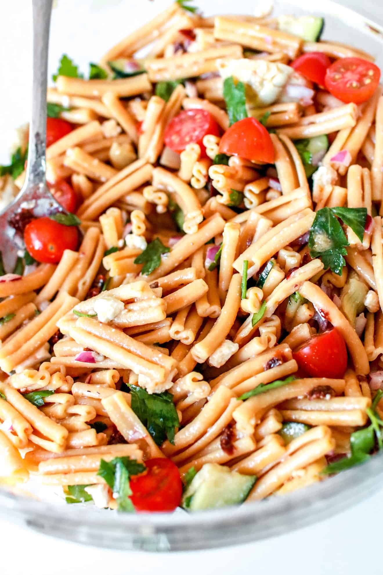 side view of chickpea pasta salad on white background