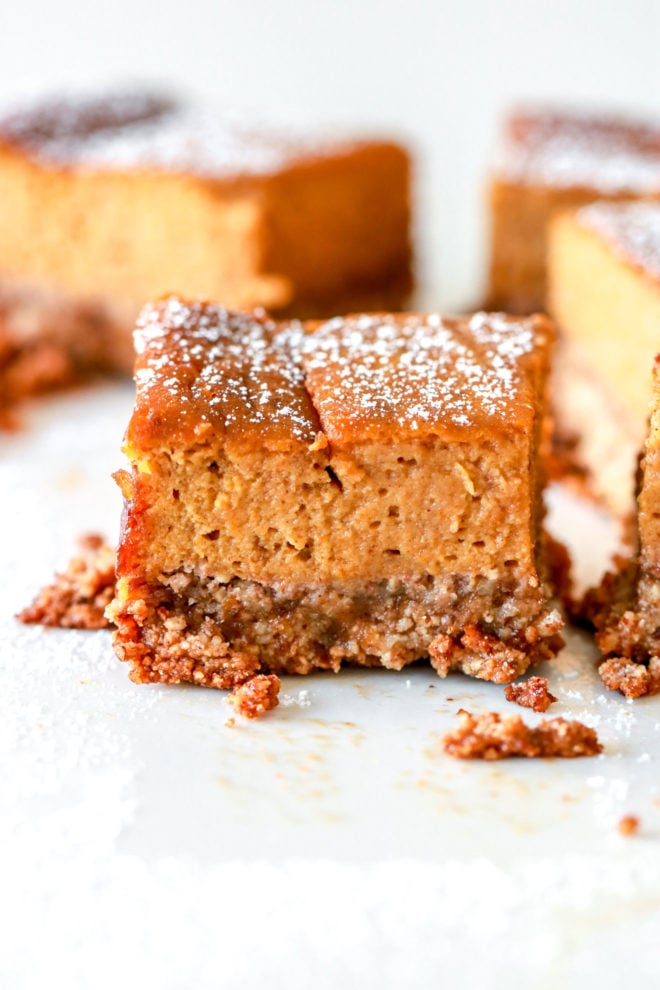 side image of gluten free pumpkin pie squares with powdered sugar sprinkled on top