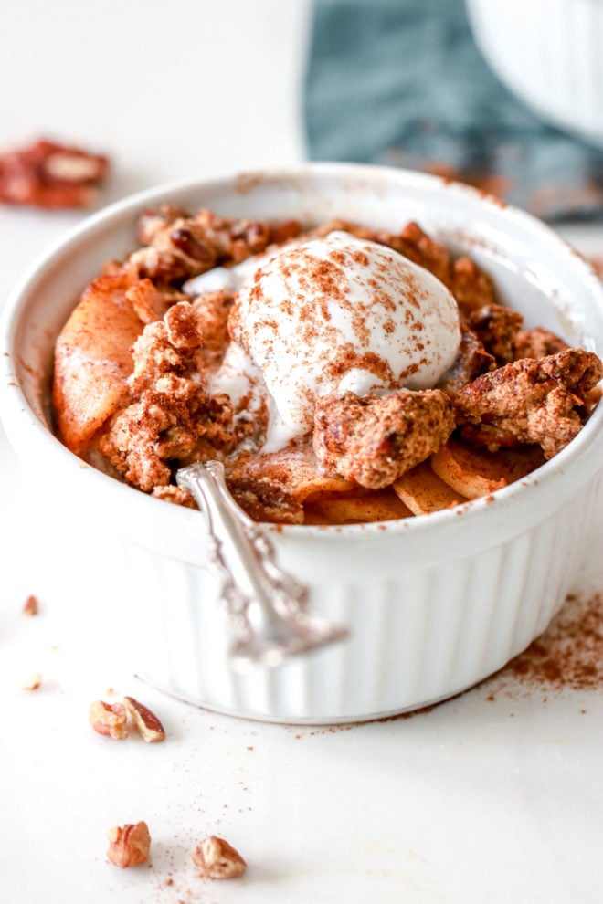 side image of apple crisp with vanilla ice cream and a spoon
