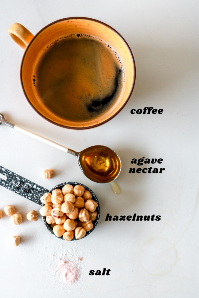 coffee, hazelnuts, agave nectar, and salt on a white counter with text overlay