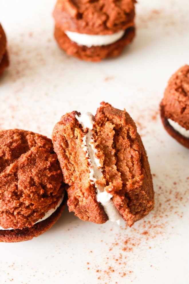 image of pumpkin whoopie pies, one with a bite taken out of it leaning on another full one