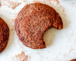 overhead image of snickerdoodles, one with a bite taken out of it