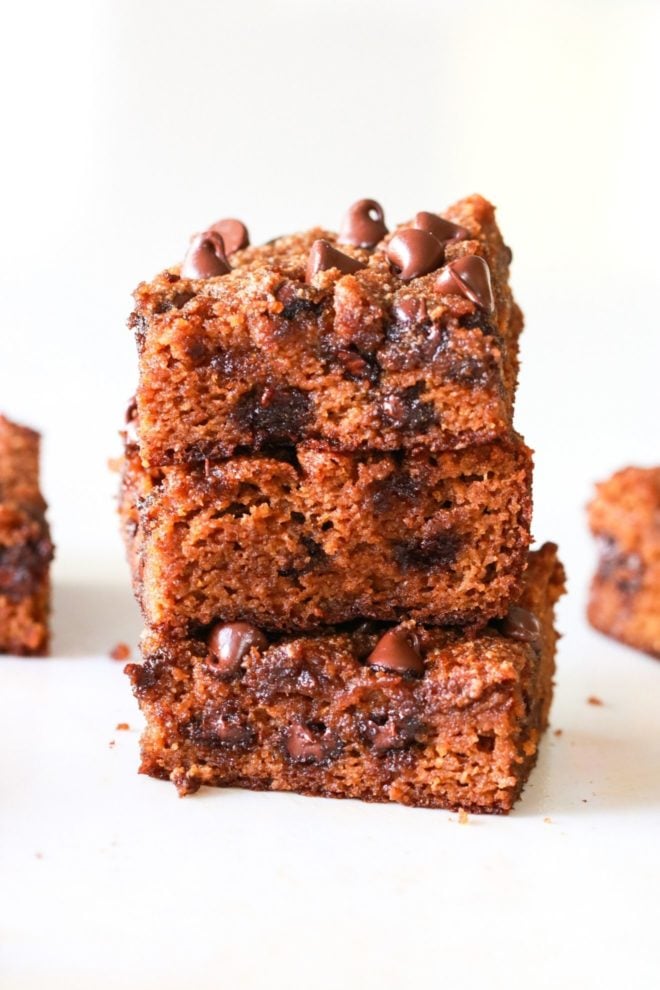 stack of three pumpkin spice blondies with chocolate chips on white counter and white background