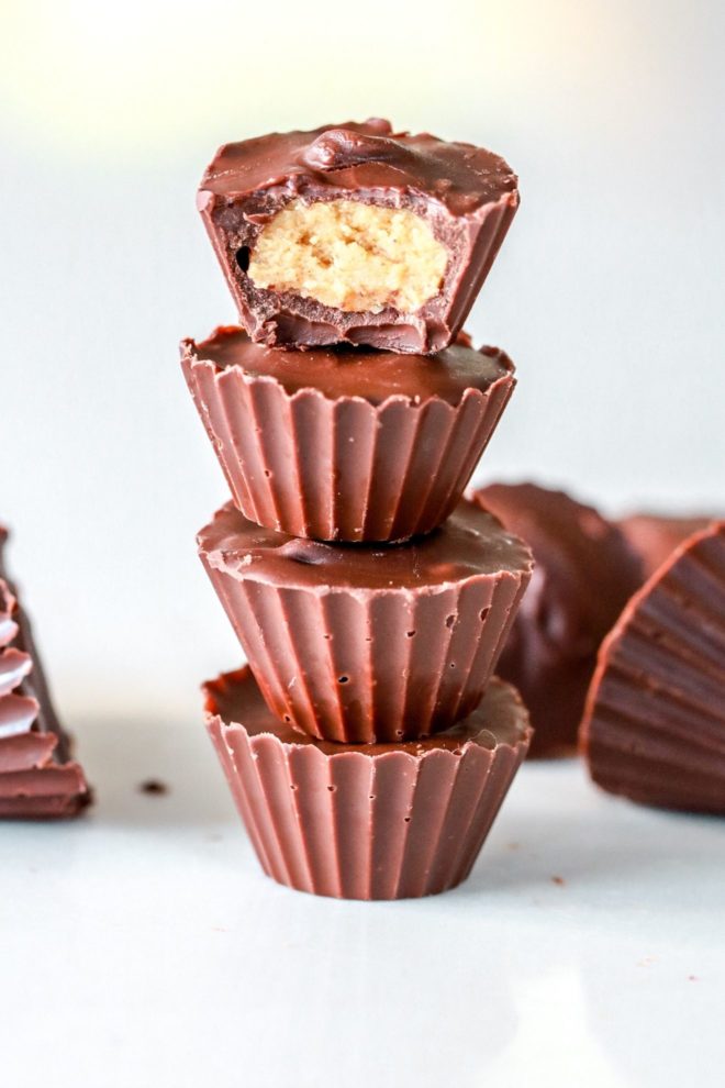 stack of four chocolate peanut butter cups, the top one with a bite taken out