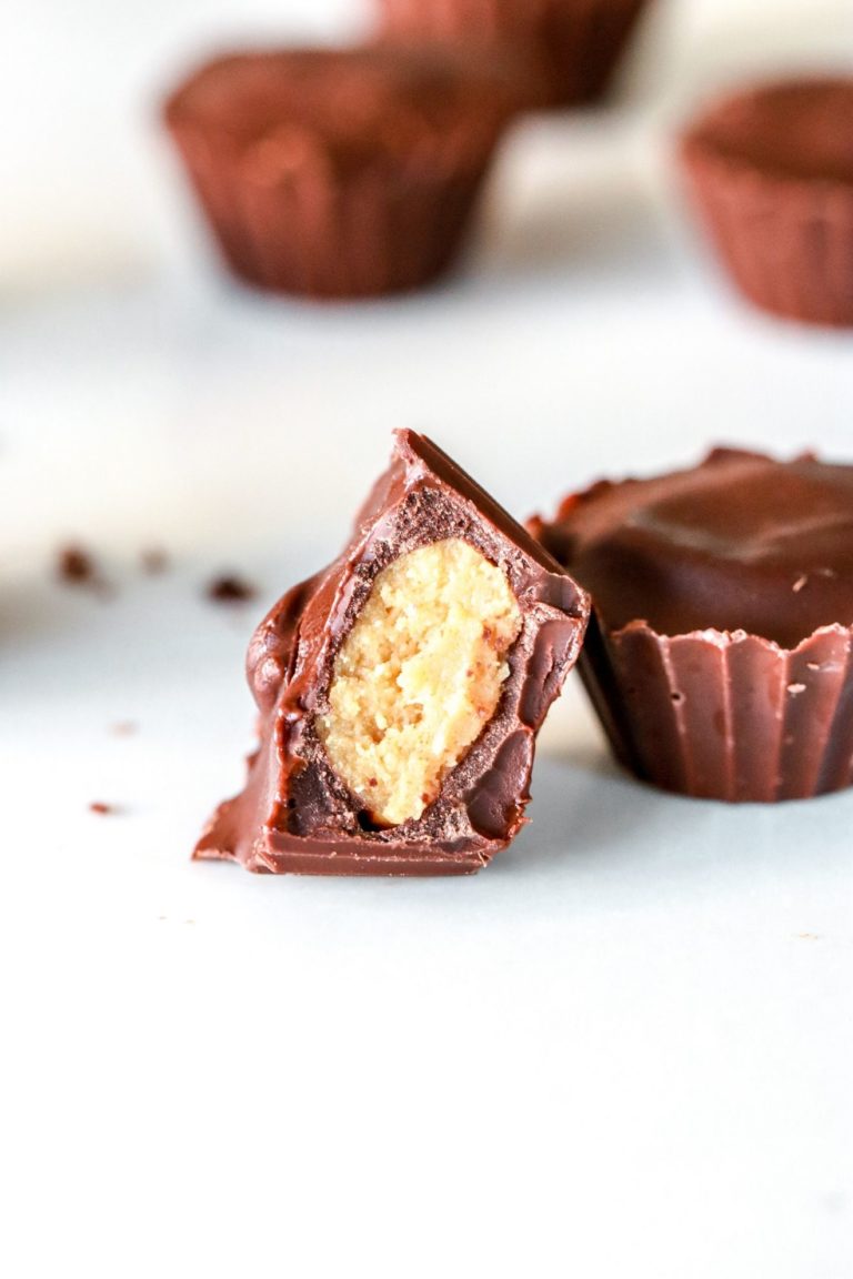 side angle of chocolate peanut butter cups, one leaning against the other with a bite taken out