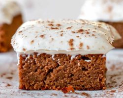 side view of pumpkin cake with cream cheese frosting and cinnamon sprinkled on top