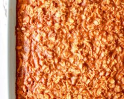overhead image of a light blue baking dish on a white counter with pumpkin oatmeal in it