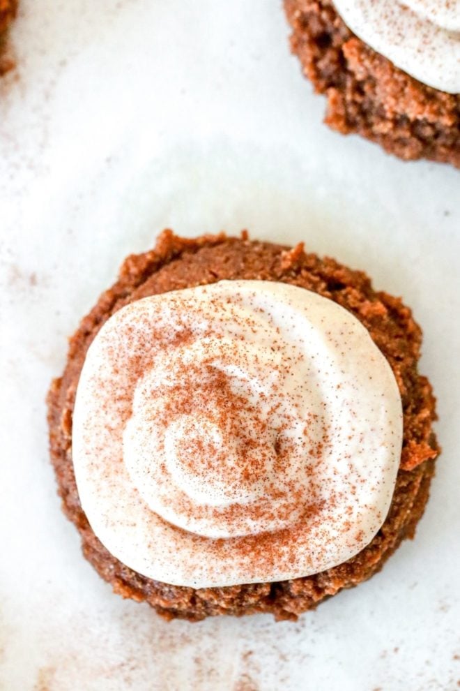 close up overhead image of a pumpkin roll cookie with cream cheese icing and a sprinkle of cinnamon