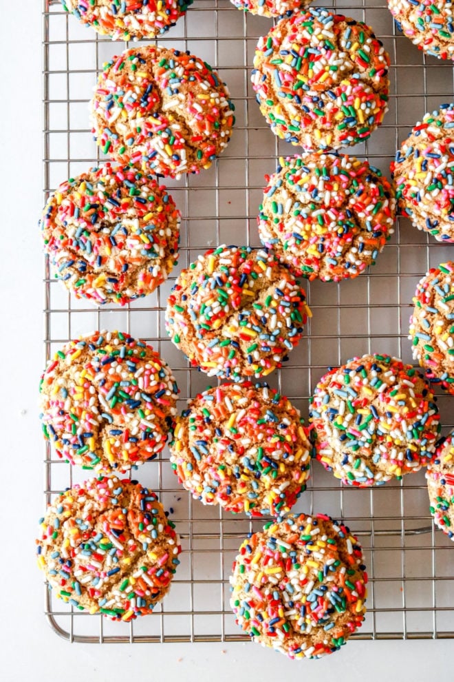 overhead image of a cooling rack filled with rainbow sprinkle cookies