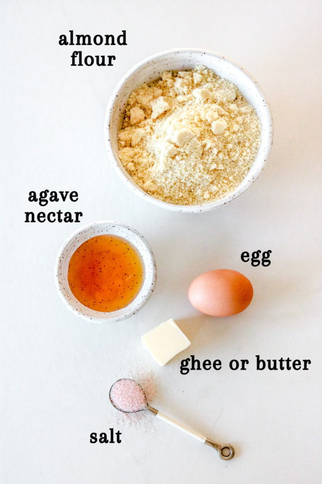 overhead image of almond flour, agave nectar, egg, butter, and salt on a white counter