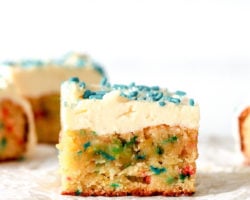 side view of sprinkle funfetti cake with vanilla icing on top
