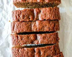 overhead image of slices of gingerbread banana bread on a wrinkled white piece of parchment paper