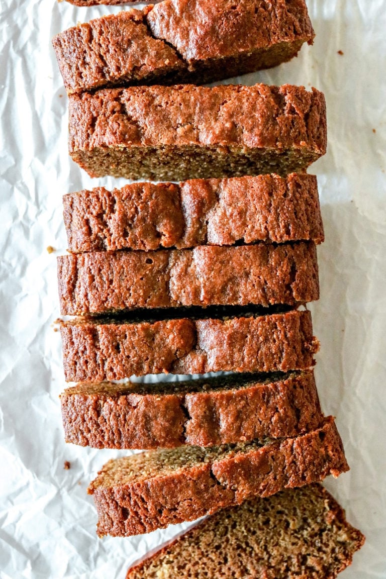 overhead image of slices of gingerbread banana bread on a wrinkled white piece of parchment paper