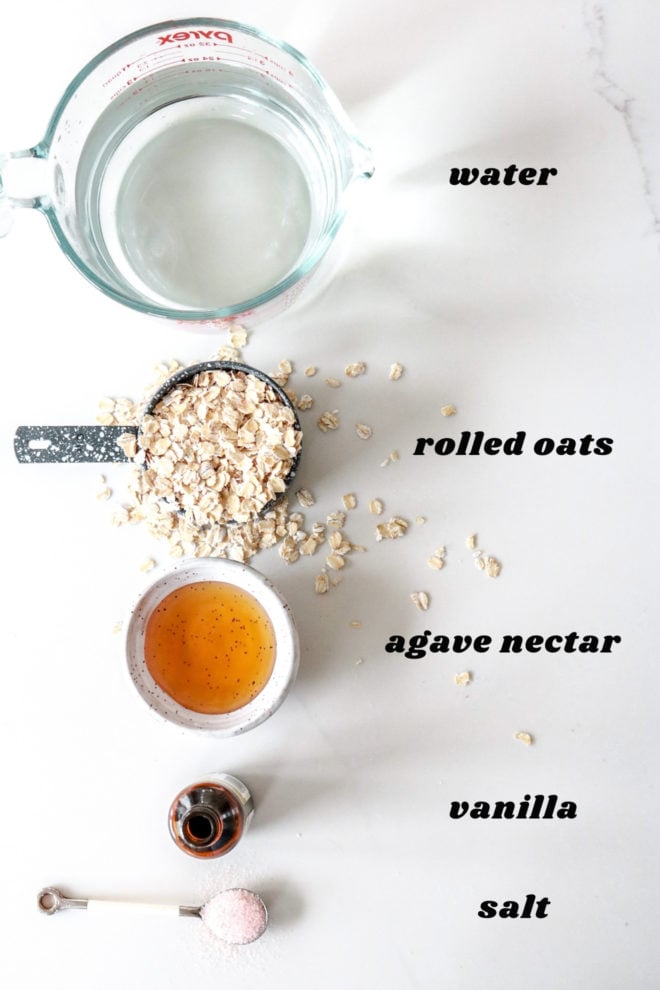 overhead image of ingredients to make oat milk on white counter