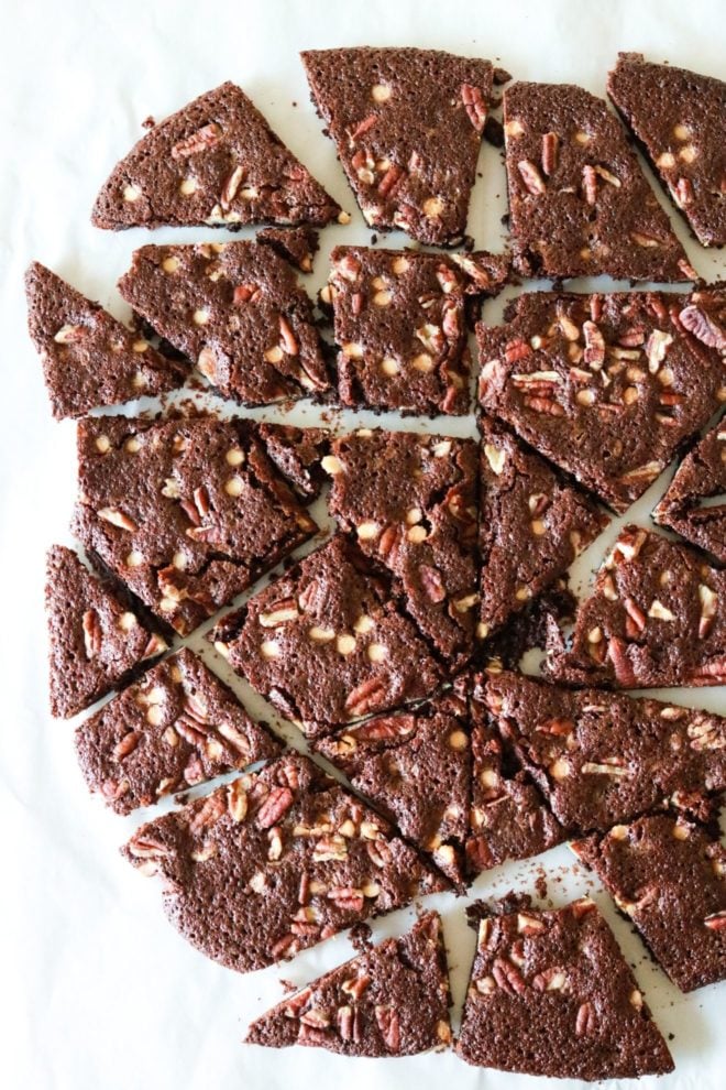 This is an overhead image of brownie brittle cut into various size pieces. The brownie crisps sit on a white counter.
