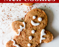 This is an overhead image of of a gingerbread man with decorative icing and a sprinkle of cinnamon with a bite taken out. The gingerbread man ays on a white counter and the image has text overlay "gluten free gingerbread men cookies."
