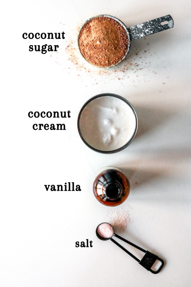 overhead image of four ingredients: coconut sugar, coconut cream, vanilla, and salt on a white counter. text overlay reads "coconut sugar, coconut cream, vanilla, salt"