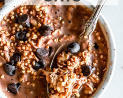 This is an overhead image of a bowl filled with chocolate oats, chocolate chips, and puffed quinoa. A spoon is scooping up a bite of the oats. The bowl sits on a white counter. Text overlay reads "chocolate overnight oats."