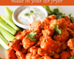This is a side view and close up image of cauliflower florets on a plate. The florets are coated in buffalo sauce. A small bowl of creamy dressing and celery is in the background. Text overlay reads "air fryer buffalo cauliflower made in your air fryer."