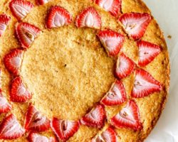 This is an overhead image of strawberry lemon cake. The cake sits on a white piece of parchment paper.