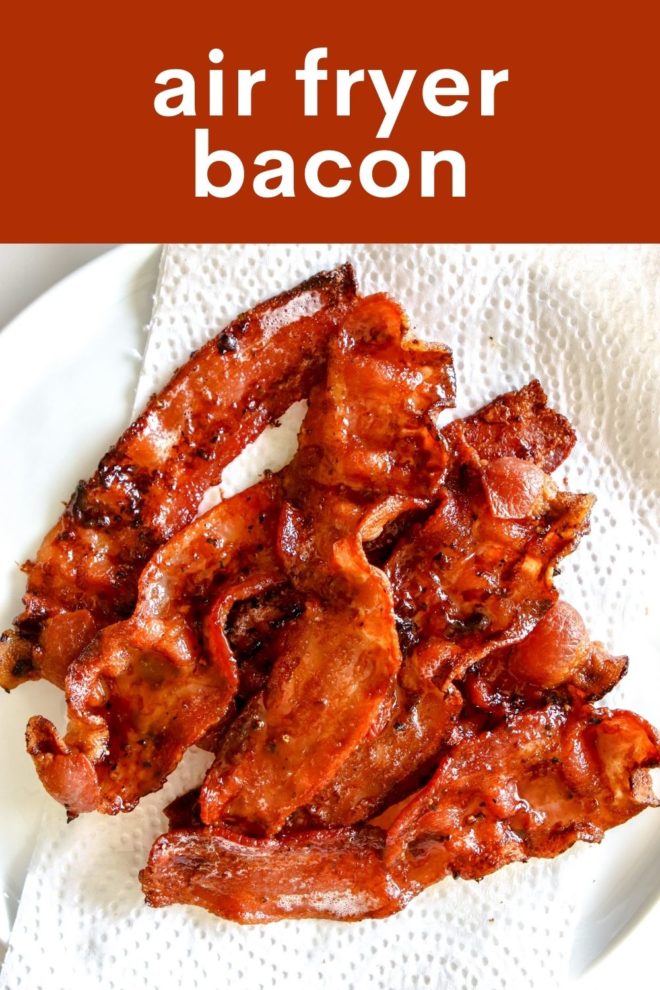 This is an overhead image of cooked slices of bacon on a white plate lined with a paper towel. The plate sits on a white counter. Text overlay reads "air fryer bacon."