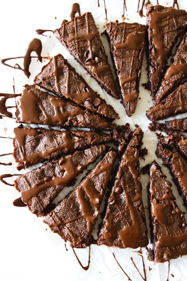 This is an overhead image of a brownie cake cut into 16 slices and drizzled with melted chocolate.