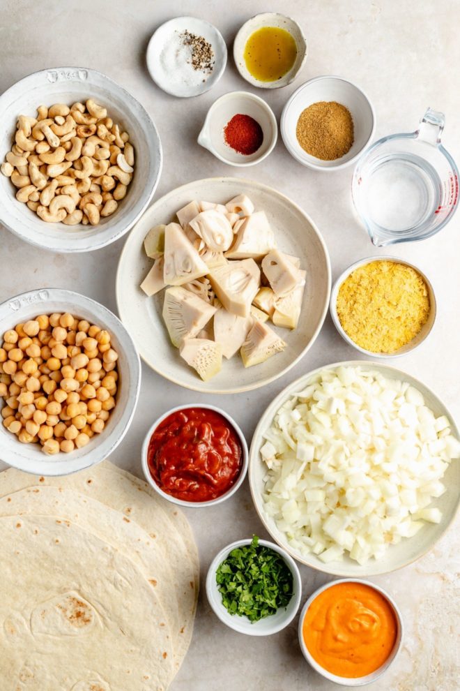 This is an overhead image of all the ingredients needed to make vegan quesadillas. The ingredients sit on a white surface.