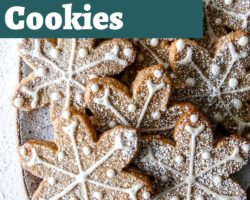 This is an overhead image of a rectangle plate with snowflake cutout cookies. The cookies are iced with a vanailla royal icing and sprinkled with powdered sugar. Text overlay reads "vegan shortbread cookies with royal icing!"