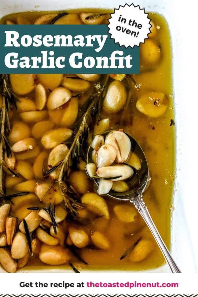 This is an overhead image of a white dish with garlic cloves in oil and a rosemary sprig. The dish sits on a white counter and an antique spoon is dipping into the dish to scoop up the garlic cloves. Text overlay reads "rosemary garlic confit in the oven!"