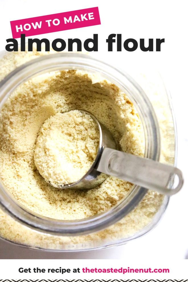 This is an overhead vertical image of a large glass container with light tan flour in it. A stainless steel measuring cup is in the jar with some flour filling it. The jar sits on a white counter. Text overlay reads "how to make almond flour"