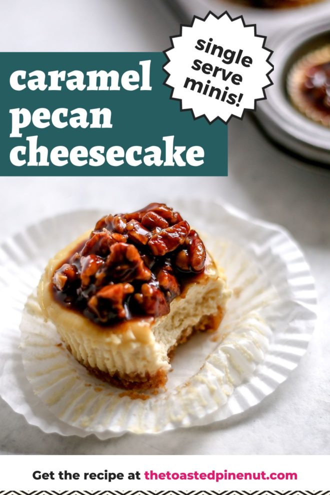 This is a side view of an individual cheesecake with a white cupcake liner pulled away and a bite taken out of it. The individual cheesecake has a caramel pecan topping and is sitting on a white surface. A muffin tin filled with more individual cheesecakes is blurred in the background. Text overlay reads "caramel pecan cheesecake single serve minis!"