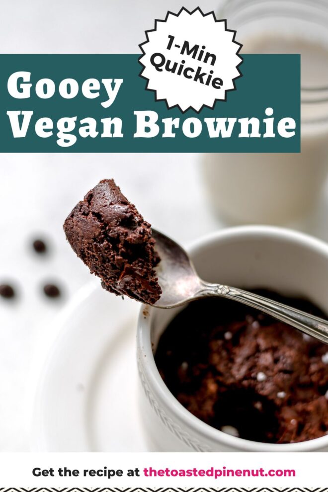 This is a vertical image looking at a side view of a silver spoon with fudgey chocolate brownie leaning against a white mug. The white mug is on a white plate and some chocolate chips and a glass of milk are blurred in the background. Text overlay reads "1-min quickie gooey vegan brownie."