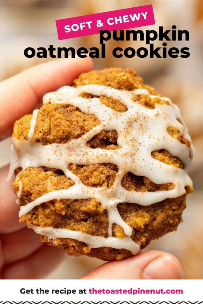 This is a vertical image focusing closeup on a left hand holding a pumpkin oatmeal cookie. The cookie is drizzled with white icing and a pumpkin spice. More cookies are blurred in the background. Text overlay reads "soft & chewy pumpkin oatmeal cookies."