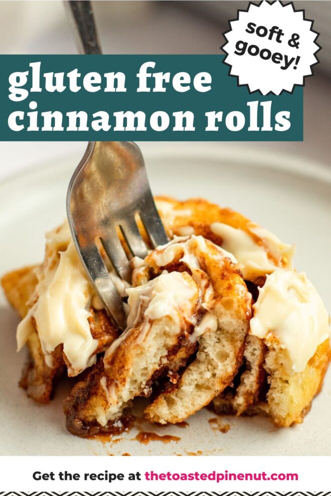 This is a vertical image looking at a cinnamon roll from the side with shite vanilla frosting on it. A fork is coming in from the top of the image and piercing the center of the roll. The cinnamon roll sits on a small white plate on a white marble counter with a white casserole dish blurred in the background. Text overlay reads "soft & gooey gluten free cinnamon rolls."
