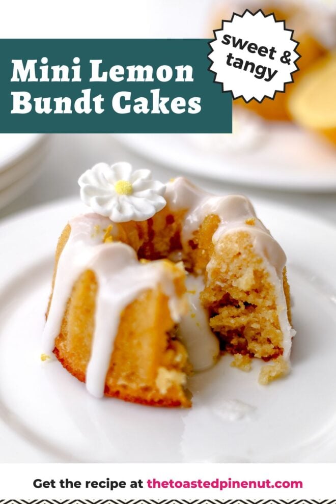 This is a vertical image of a mini bundt cake on a small white plate. The image is looking at the cake from the side. The cake has a white glaze on top and dripping down the sides and middle. A white sugar flower is on top of the bundt cake. Another plate with a mini bundt cake and a lemon wedge is on a small white plate blurred in the background. Text overlay reads "sweet & tangy mini lemon bundt cakes."