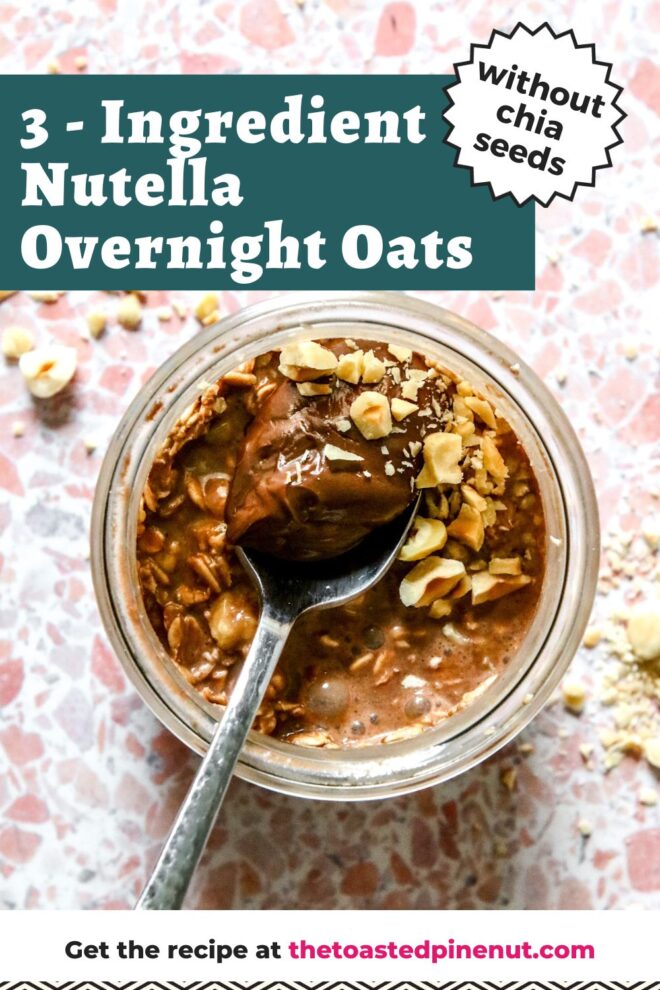 This is an overhead vertical image of a glass jar with chocolate overnight oats in it. A silver spoon is dipping into the oats with the handle leaning against the bottom left side of the jar. Crushed nuts are on top of the chocolate oats and on the pink terrazzo surface around the jar. Text overlay reads "3 - ingredient nutella overnight oats without chia seeds" at the top and "get the recipe at thetoastedpinenut.com" at the bottom.