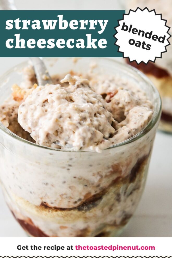 This is a vertical image looking at a glass jar from the side. In the glass jar are layers of graham cracker crumbs, strawberry jam, and a light pink almost white mixture with specks of seeds in it. A silver spoon is in the jar scooping up the oats and leaning against the side of the jar. Another glass jar with similar layers is behind the fro centered jar blurred in the background. The jars sit on a white square tile surface. Text overlay reads "strawberry cheesecake blended oats."